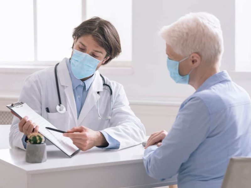 Médico atendendo paciente e analisando como preparar sua clínica para receber pacientes pós Covid-19.