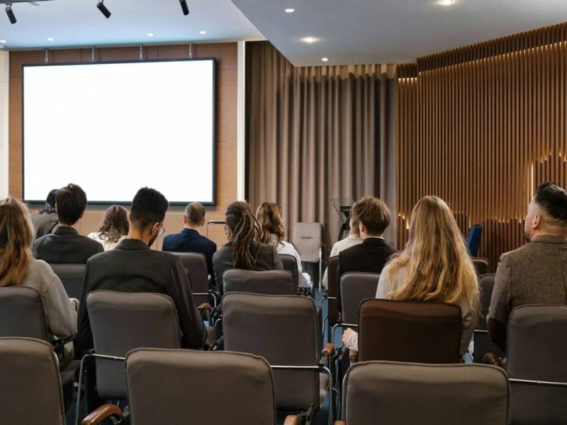 medicos participam de um congresso medico em um sala, com um telao em branco