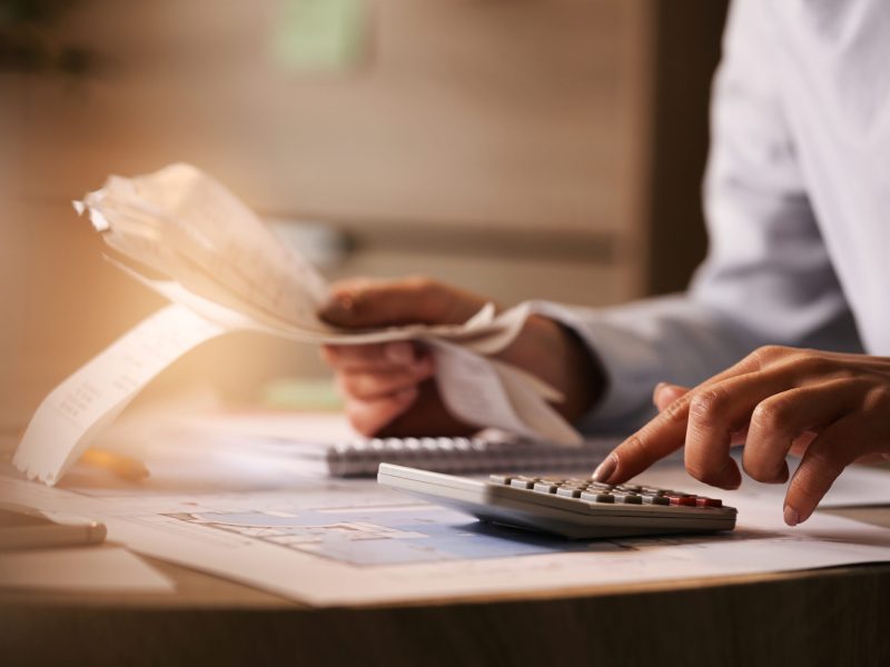 Pessoa usando uma calculadora em uma mesa para fazer contas - Foto: Freepik
