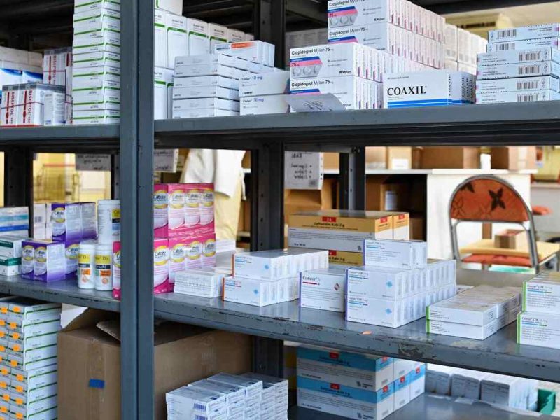 Remédios que passam por um controle de estoque de medicamentos arrumados em uma estante de ferro