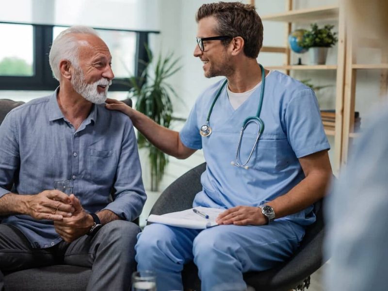 Médico e paciente lado a lado conversando sobre elegibilidade de pacientes.