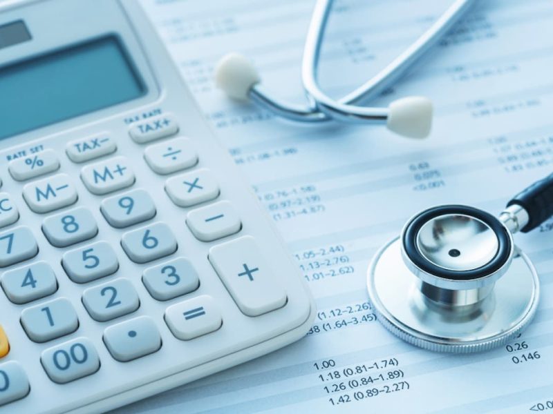 Calculadora e estetoscópio, simbolizando o faturamento de guias de médico.