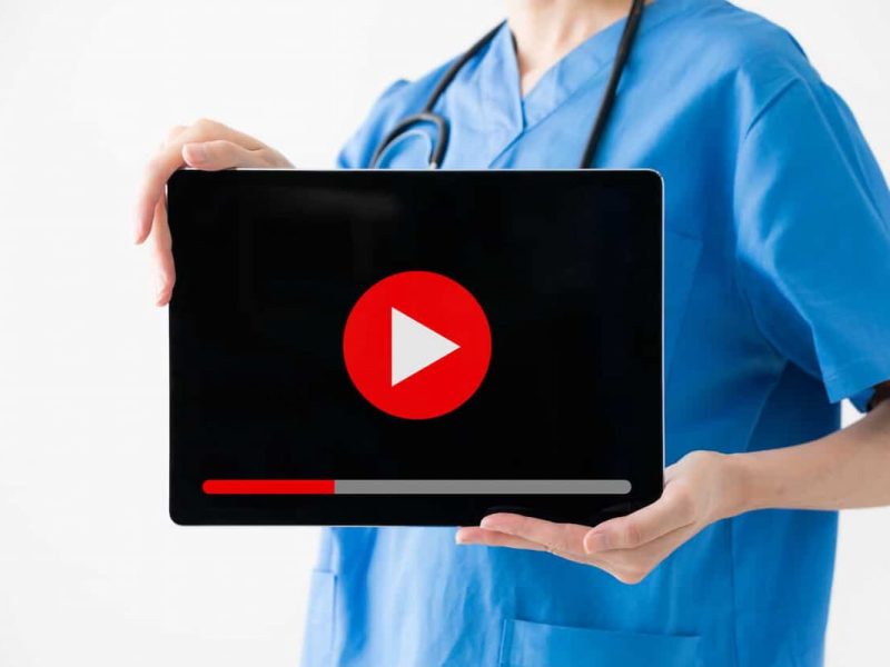 Profissional da saúde segurando laptop mostrando os filmes que todo médico deve assistir.