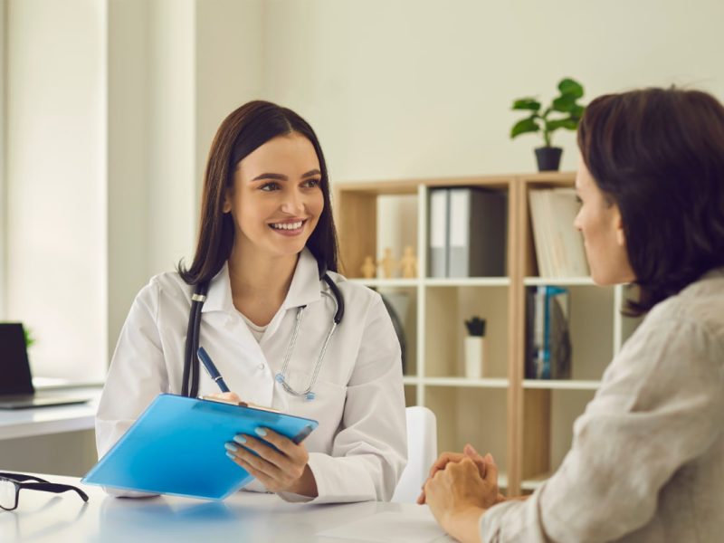 Médica atendendo paciente em consultório organizado, representando a gestão eficiente de clínicas e consultórios.