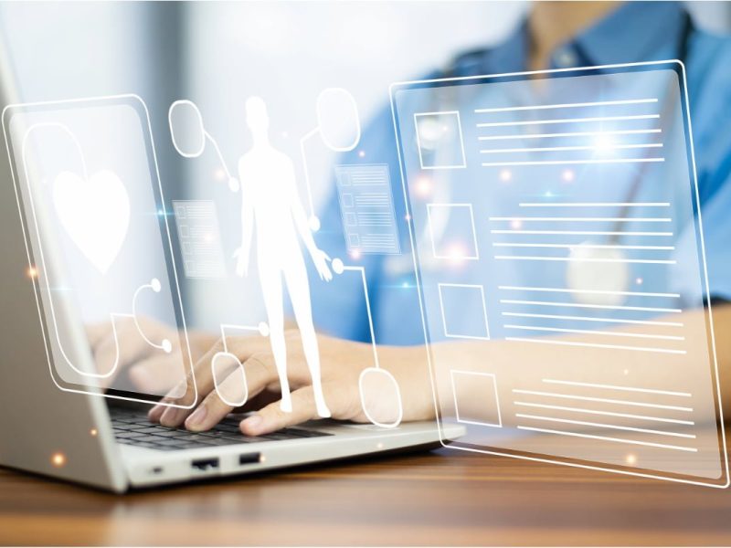 Imagem de healthtech com silhuetas humanas e ícones de saúde sobre um laptop e tela digital.