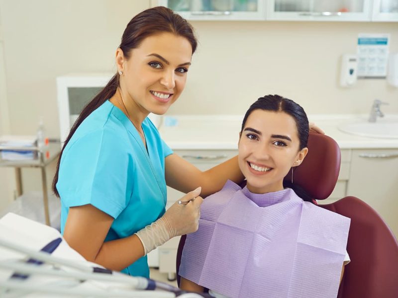 Dentista e paciente sorrindo durante consulta, simbolizando o inbound marketing para clínicas.