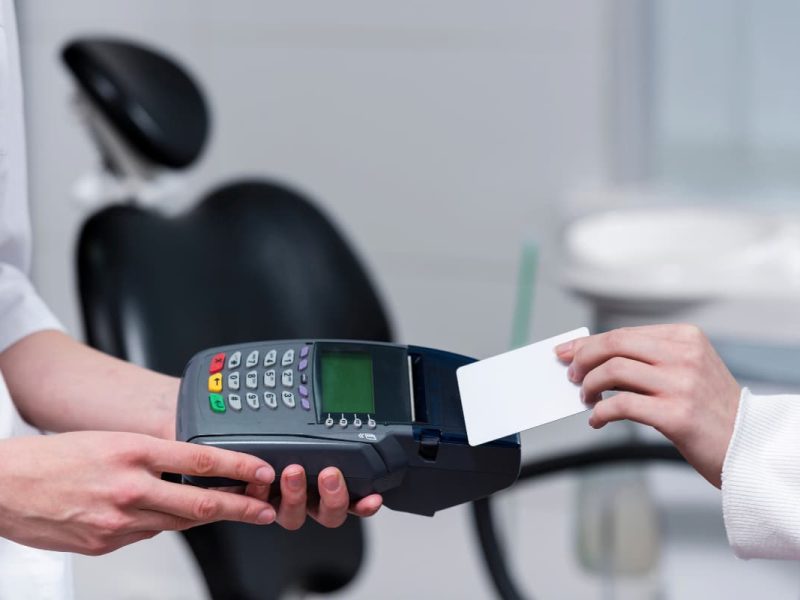 Pessoa paga com máquina de cartão menor taxa para clínicas.