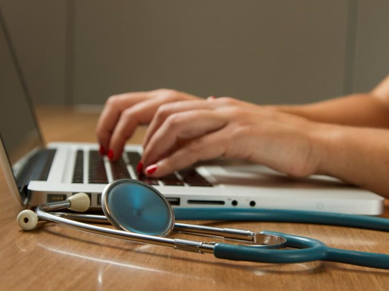 Fotografia de um médico trabalhando no seu marketing digital médico com auxílio de seu notebook.