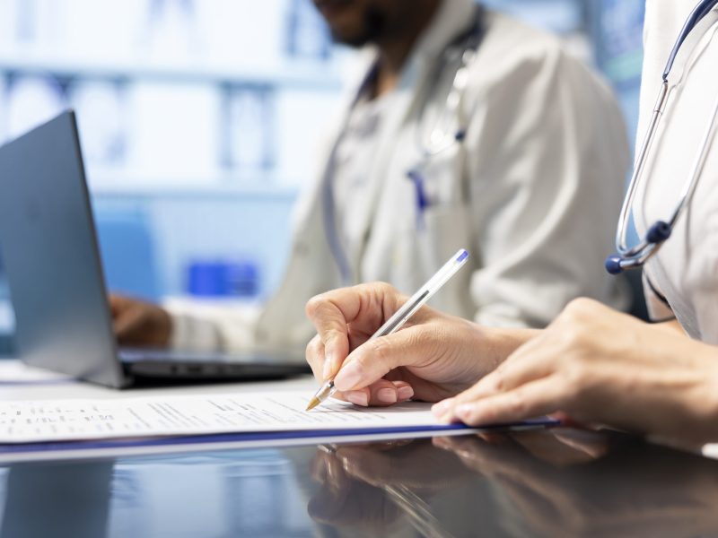 Physician writing a prescription treatment plan to help with recovery, recommending a suitable healthcare strategy based on radiography results and hospital records. Medicare meeting. Close up.