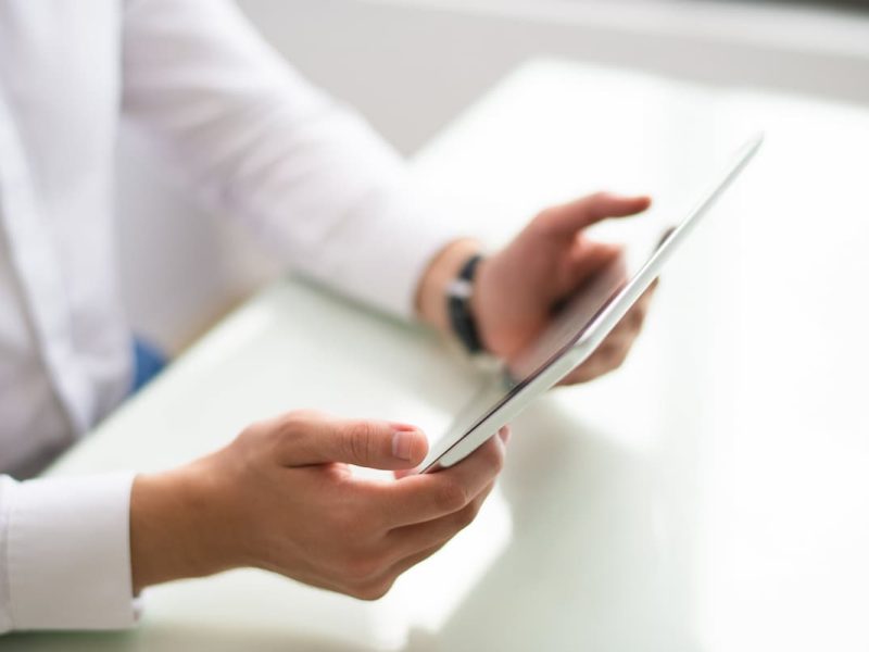 Médicos x YouTube: profissional da saúde usando um tablet para promover o trabalho no YouTube.