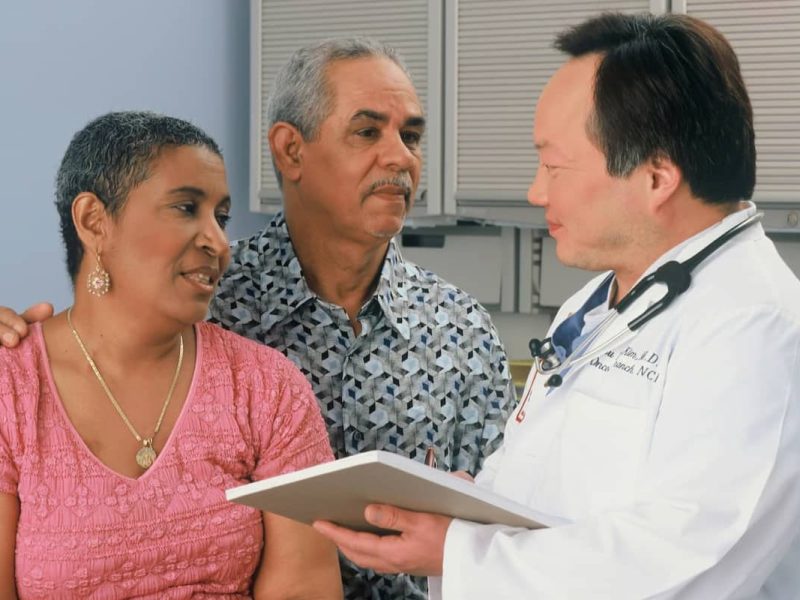 Médico conversando com pacientes quanto cobrar pela consulta médica,