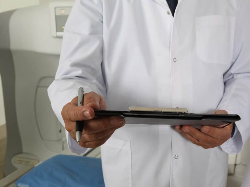 Profissional de saúde segurando um tablet com prontuário médico eletrônico, simbolizando gestão moderna de dados.