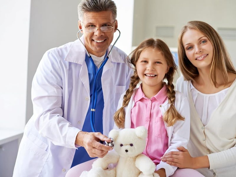 Médico com pacientes sorridentes, simbolizando como evitar queixas no consultório.