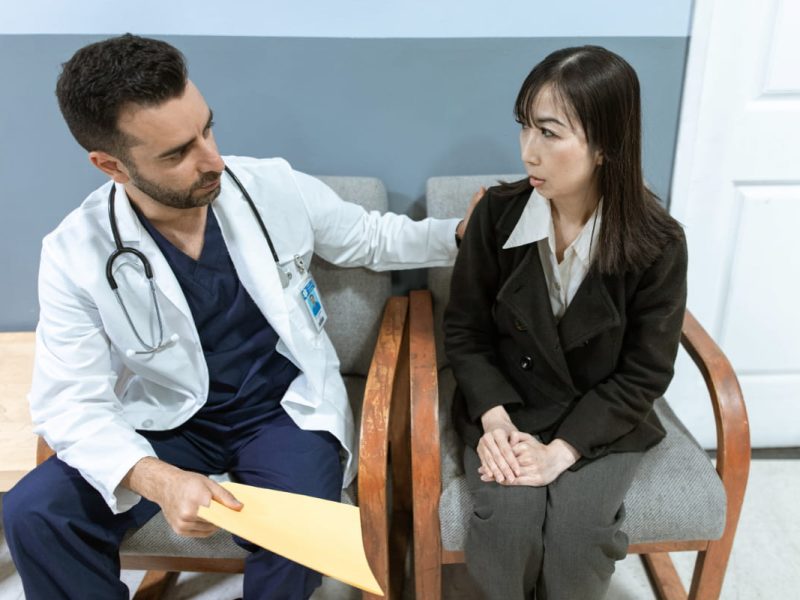 Médico confortando paciente com síndrome do jaleco branco.