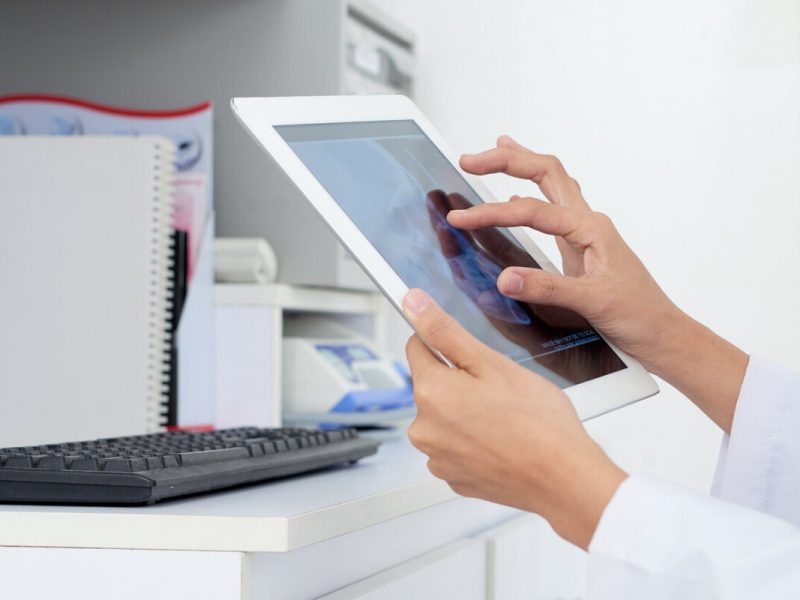 médico de jaleco branco usa o sistema de controle de estoque em um tablet