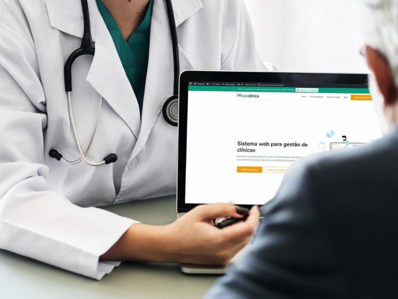 Médica apresentando sistemas de gestão de clínicas para paciente.