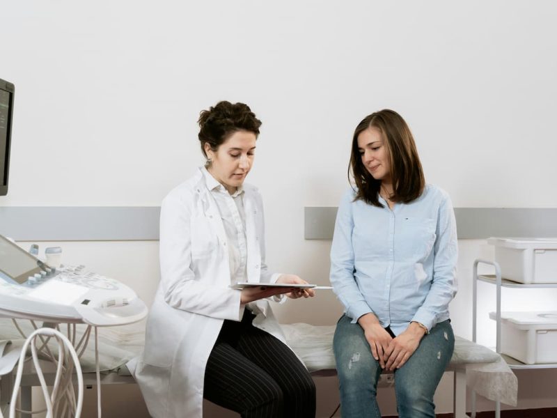 Fotografia de uma médica, que pratica a slow medicine, conversando com uma paciente.