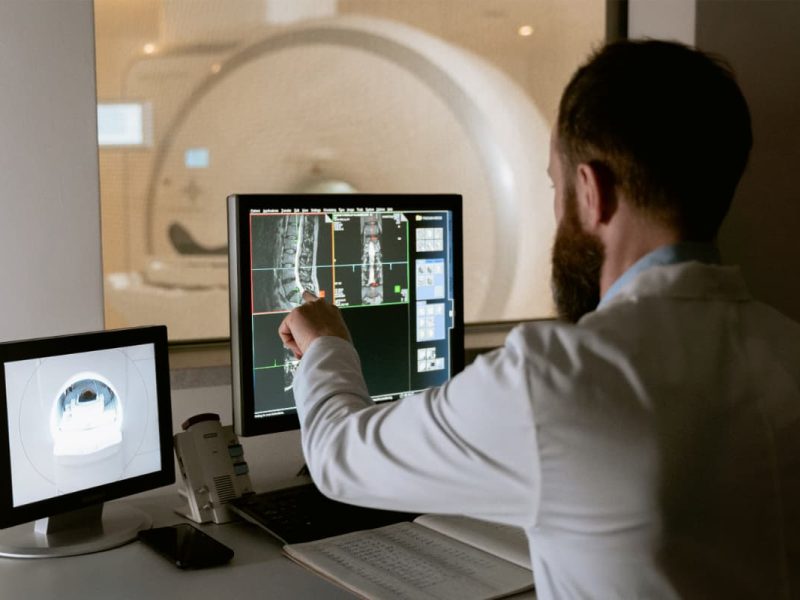 Médico analisando raio-X pelo computador, simbolizando a telerradiologia.